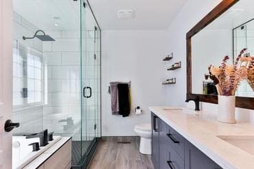 A modern bathroom with a glass shower and double vanity
