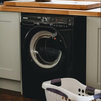 A front-loading washer under a wood countertop