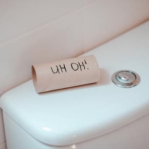 An empty toilet paper roll labelled uh oh